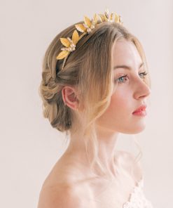 Woman with blond hair styled up on a low braid wearing an off the shoulder lace dress with large Gold festival wedding crown