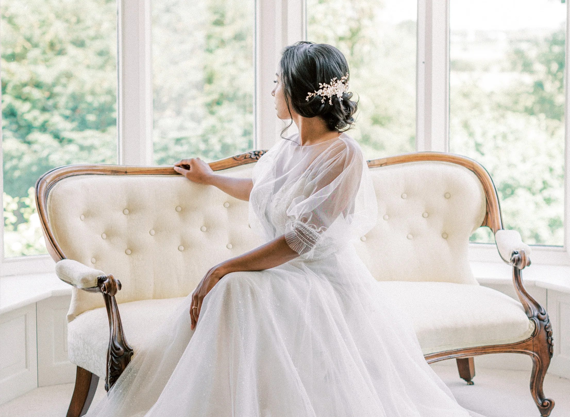 Chaise longue in window with bride sitting on it looking out of the window