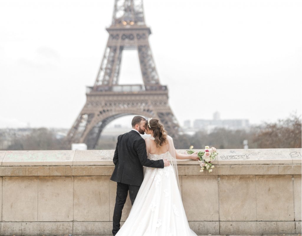 A Paris elopement city chic romance. A couple embrace in front of the Eiffel tower.